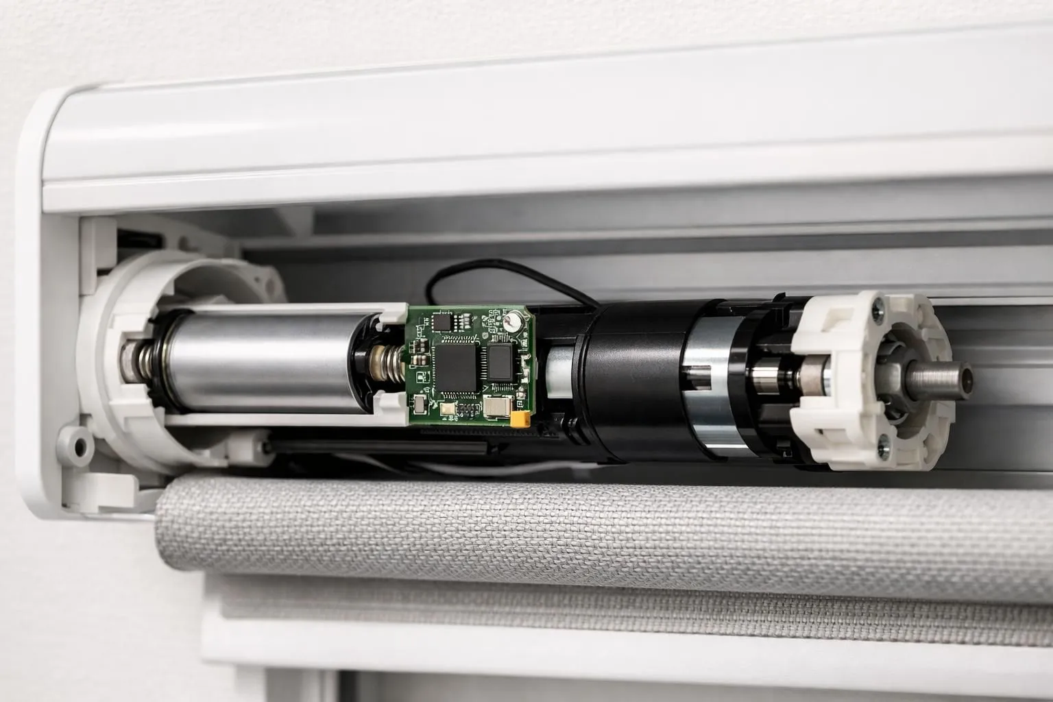 Close-up view of a tubular motor mechanism inside a white roller blind shaft, showing battery compartment with lithium-ion cell, wireless receiver chip, and compact motor components, technical detail, clean modern design, no text or labels visible