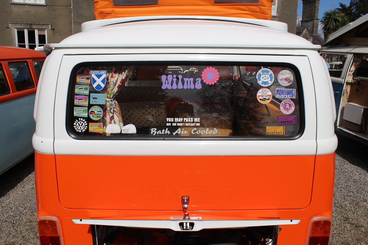 An orange and white camper van is in the photo.