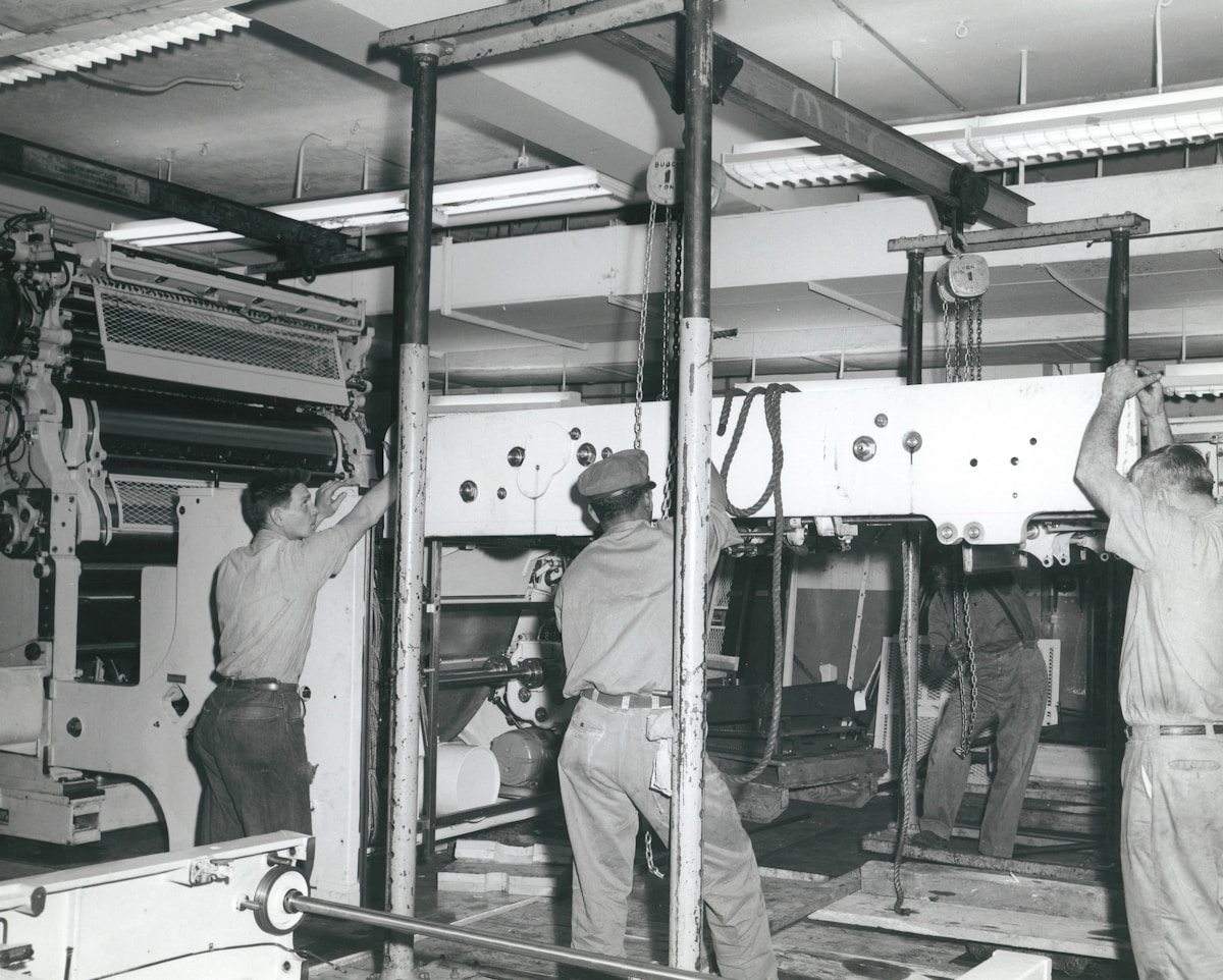 Atelier industriel avec des machines et des ouvriers au travail.