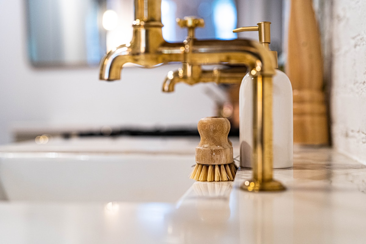Un lavabo de salle de bain avec un robinet doré à côté.