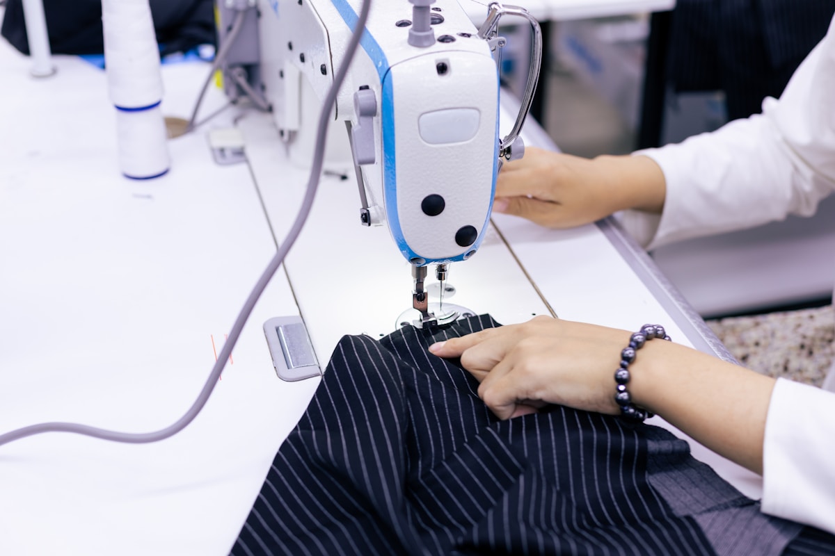 Une femme utilise une machine à coudre pour confectionner des vêtements.