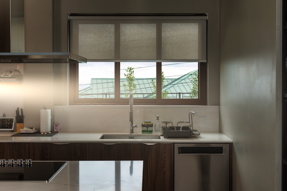 Cuisine moderne avec fenêtre panoramique, évier, comptoir en marbre.