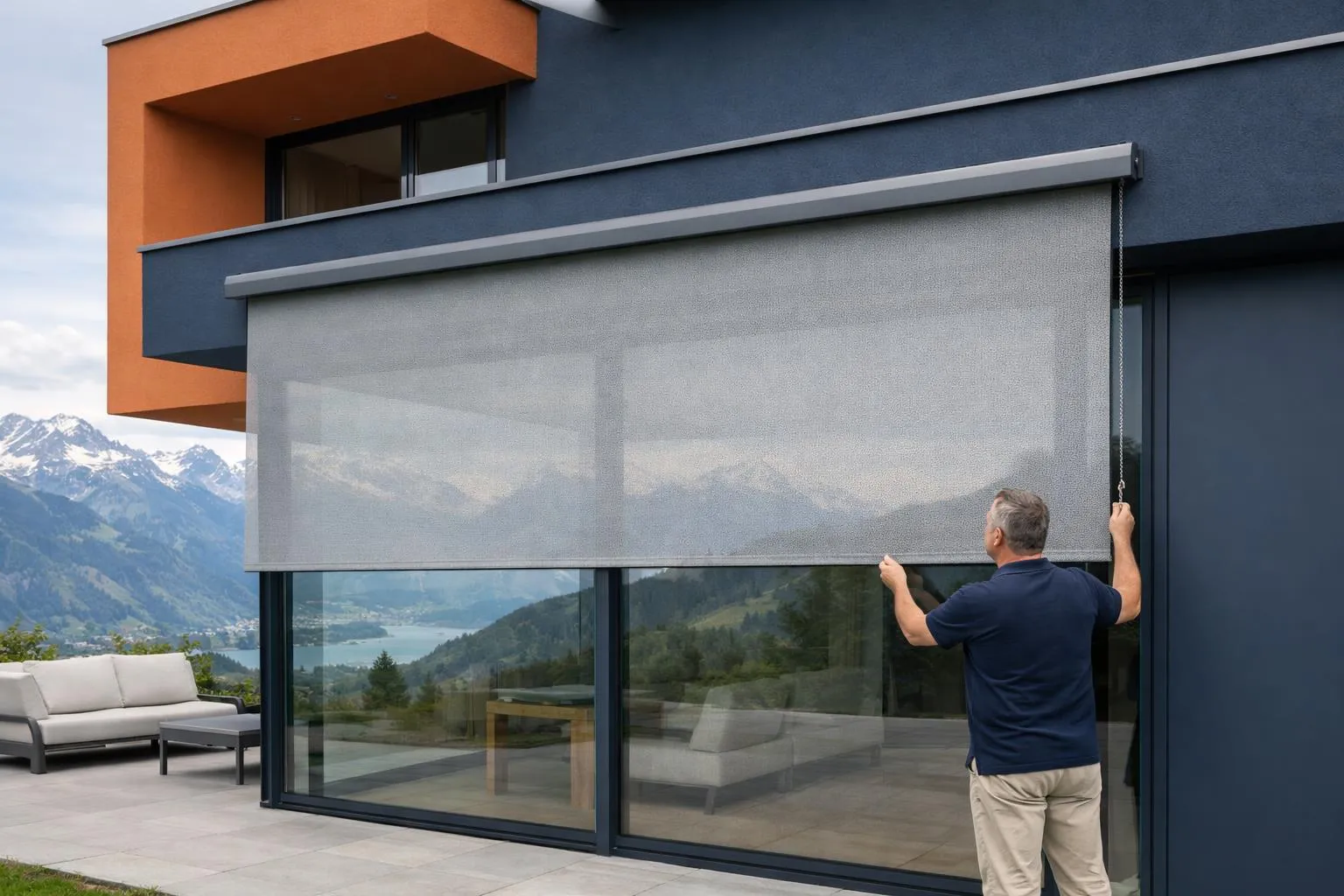 Modern exterior screen shade installed on a contemporary Swiss house facade with large windows, visible perforated fabric texture allowing filtered sunlight, Alpine landscape visible through the screen, homeowner adjusting the vertical screen from inside, clean architectural lines, daytime natural lighting showing UV protection effect