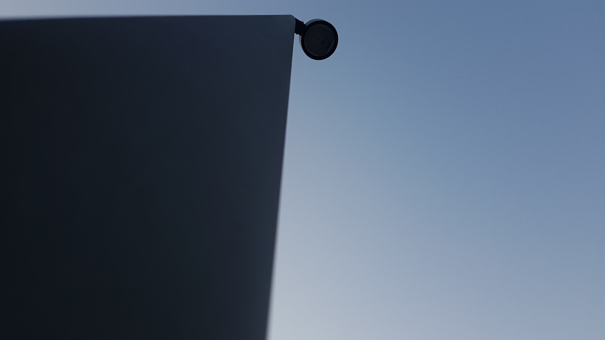Un avion vole dans le ciel au-dessus d'un bâtiment.