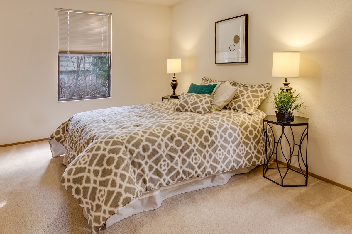Chambre à coucher confortable avec literie motif géométrique.
