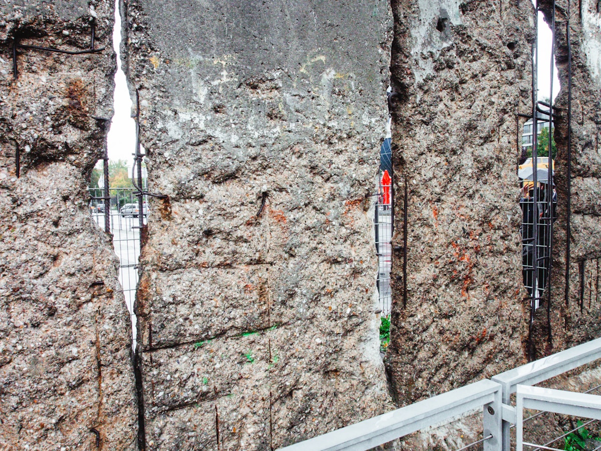 Mur de pierre grise avec câbles et barres métalliques.
