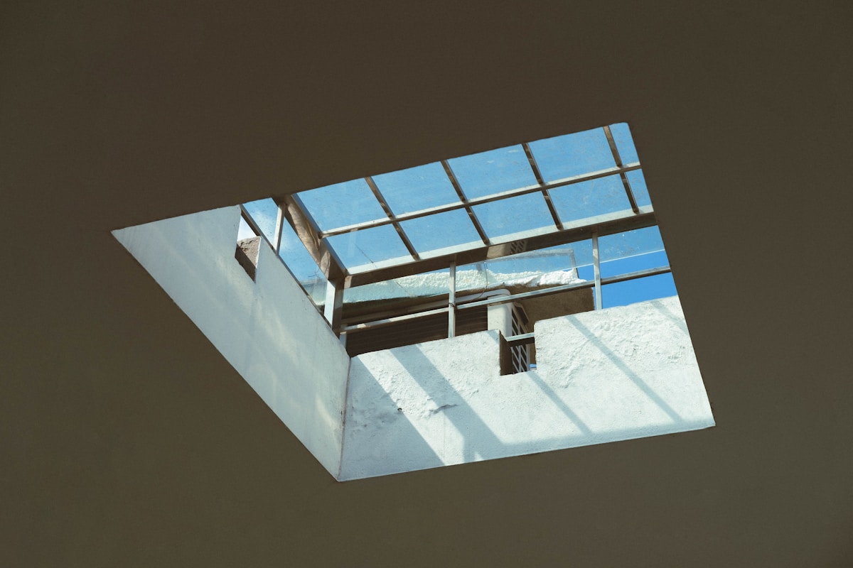 Fenêtre en verre avec cadre en métal, vue du ciel bleu.