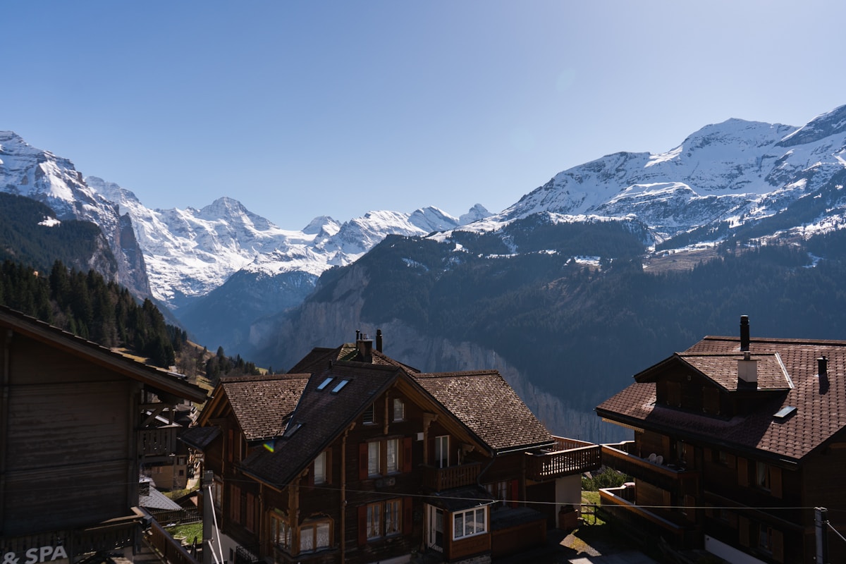 Paysage de montagnes enneigées avec des chalets traditionnels.