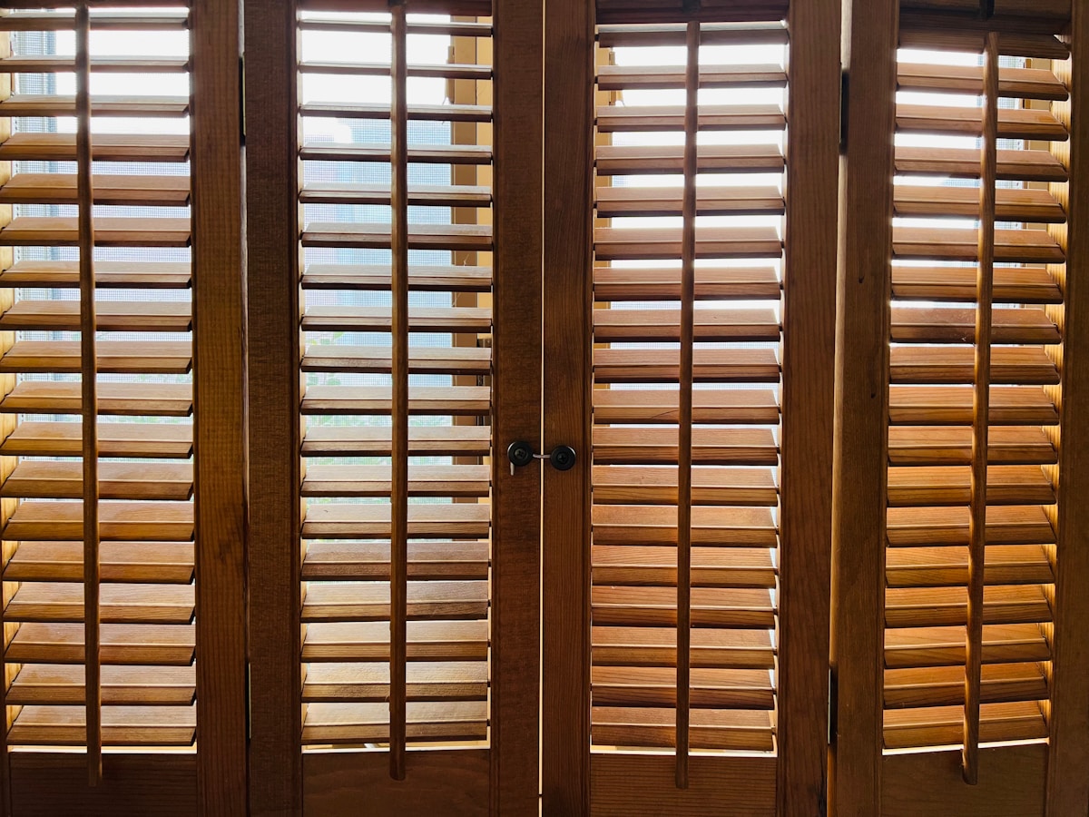 Volets en bois avec lattes horizontales et lumière tamisée.