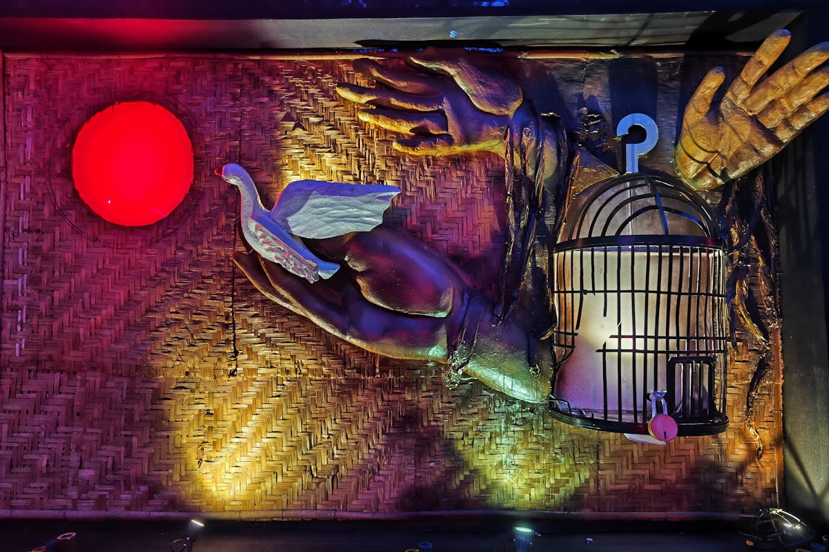 A bird in hands with a cage and red light