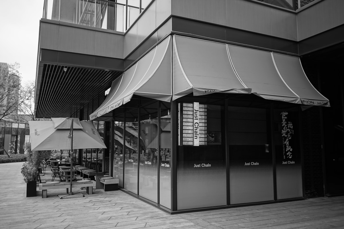 Bâtiment moderne avec terrasse et enseignes de restaurant.