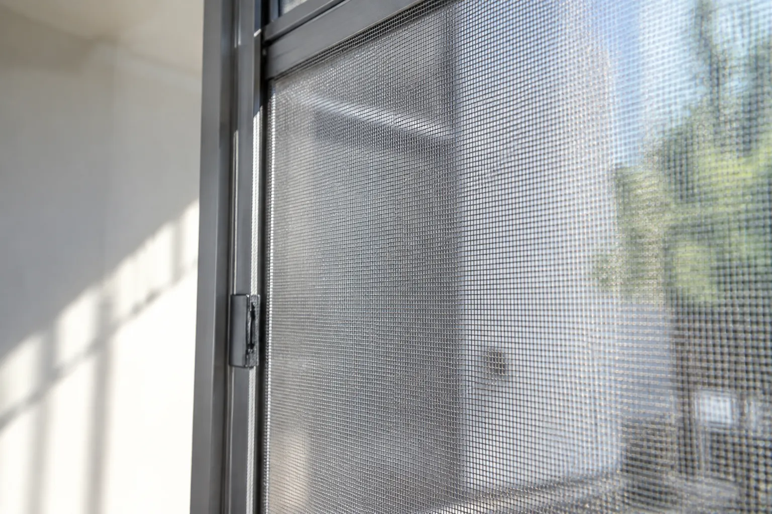 Moustiquaire en tissu suspendue, lumière filtrant à travers les mailles.