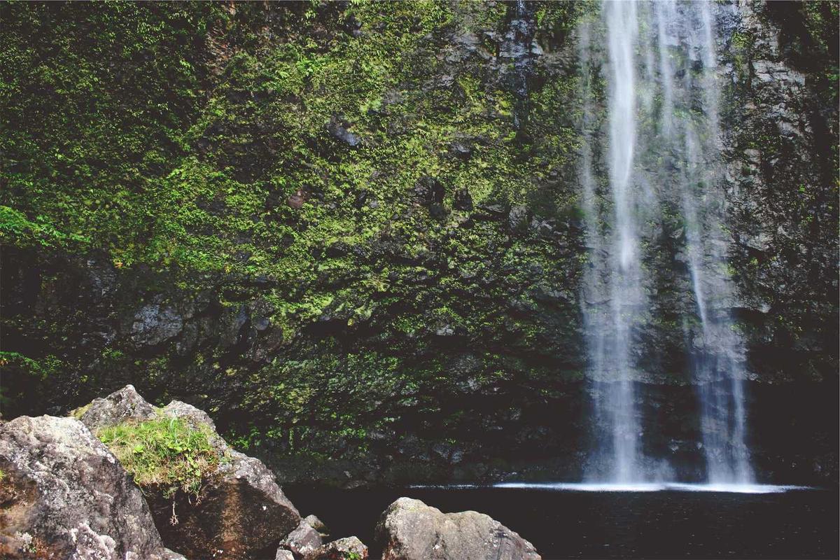 Waterfall cascading into pool, mossy rock face.