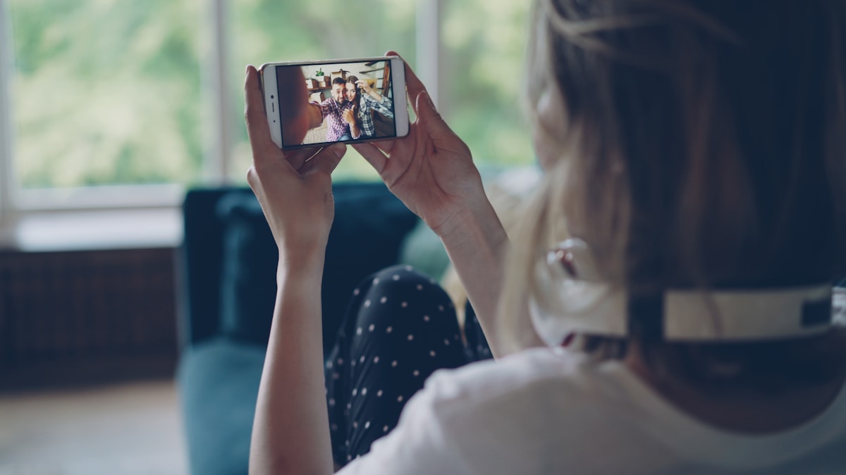 Femme prenant un selfie avec des amis sur son téléphone portable.