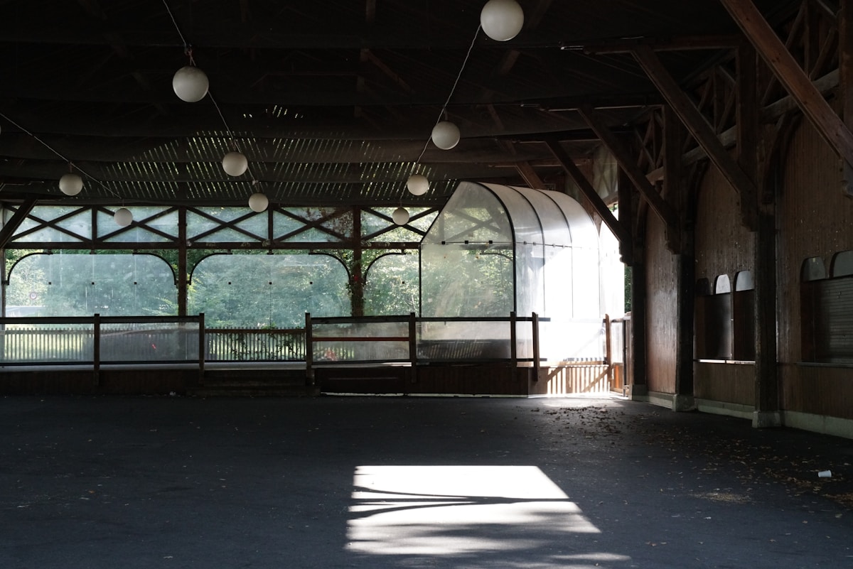 Intérieur abandonné d'un bâtiment avec fenêtres et éclairage.