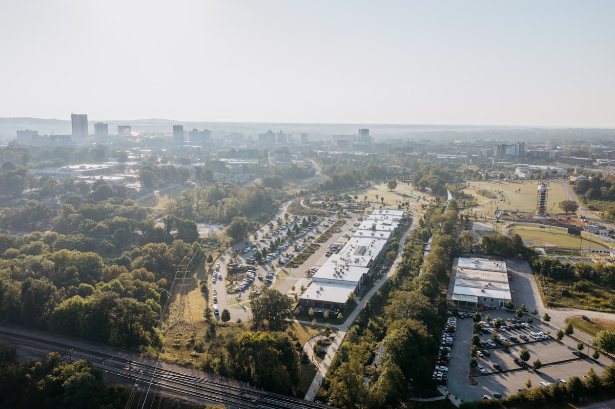 Aerial view of suburban buildings and distant city skyline.
