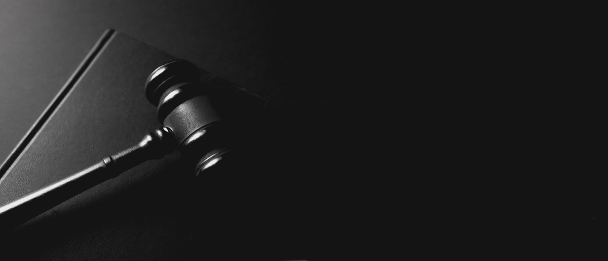 Marteau de juge sur fond sombre et contrasté.
