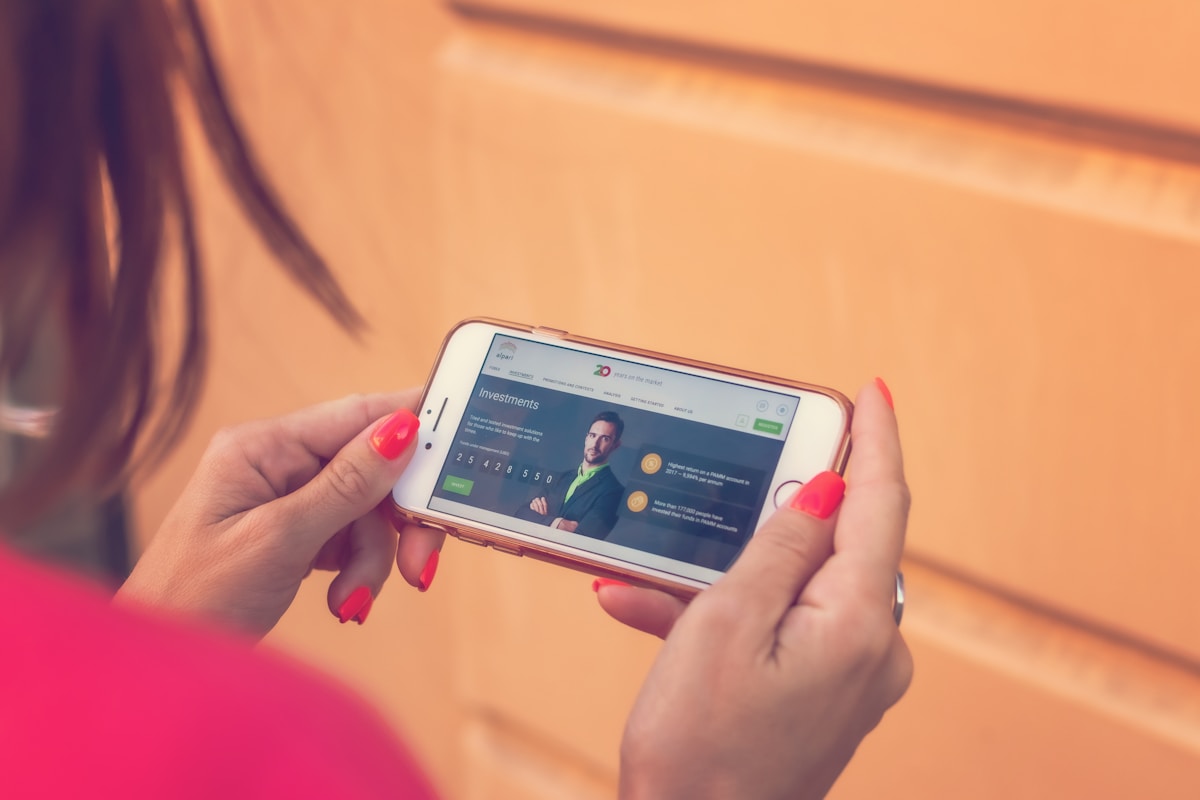 Femme utilisant une application d'investissement sur son téléphone portable.