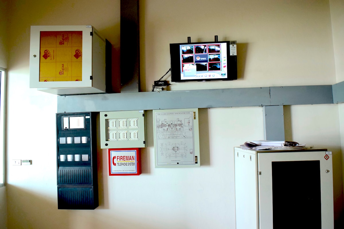Panneau de contrôle électrique, moniteur de surveillance, extincteur et schémas techniques.