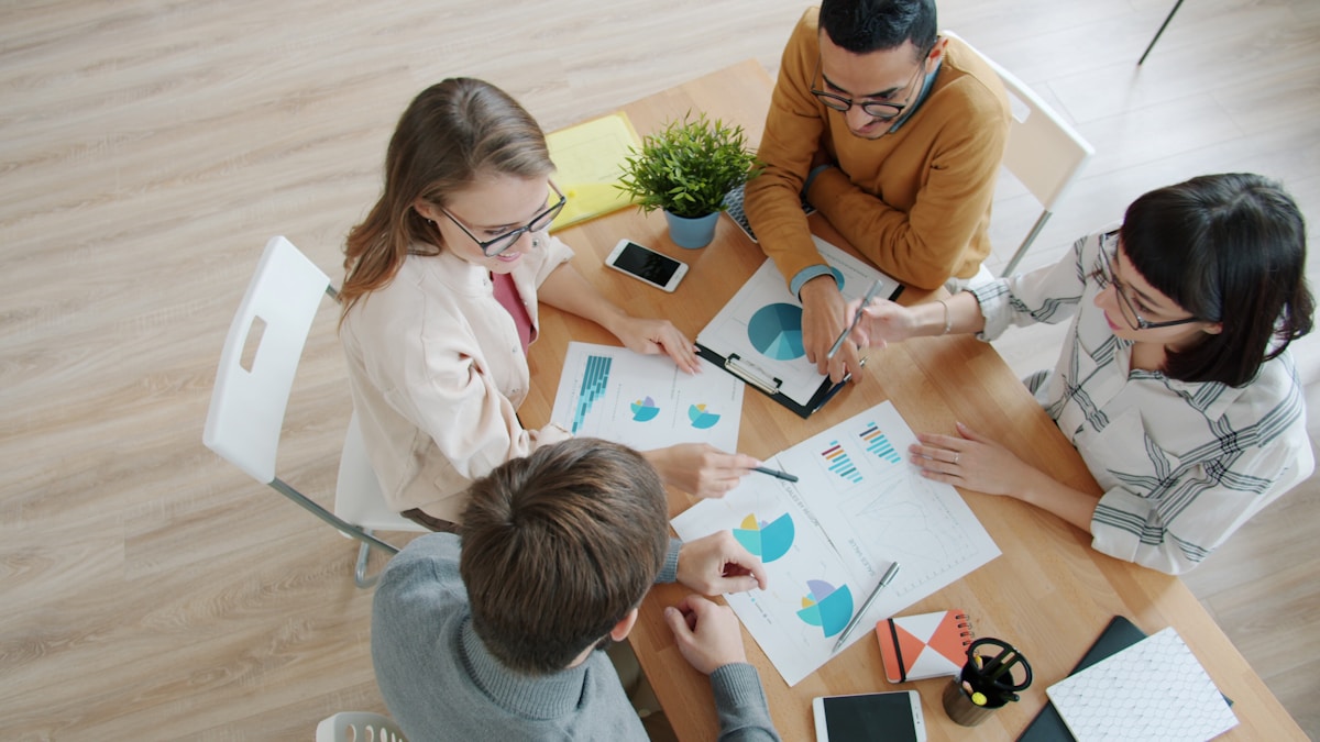Groupe de personnes travaillant ensemble sur des graphiques et des documents.