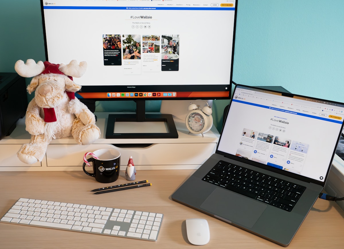 Un ordinateur portable posé sur un bureau à côté d'un moniteur.