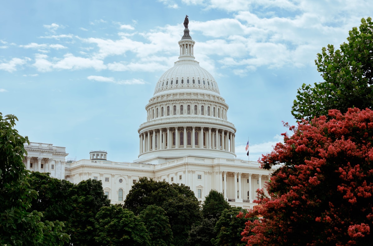 Dôme majestueux du Capitole des États-Unis entouré de verdure.