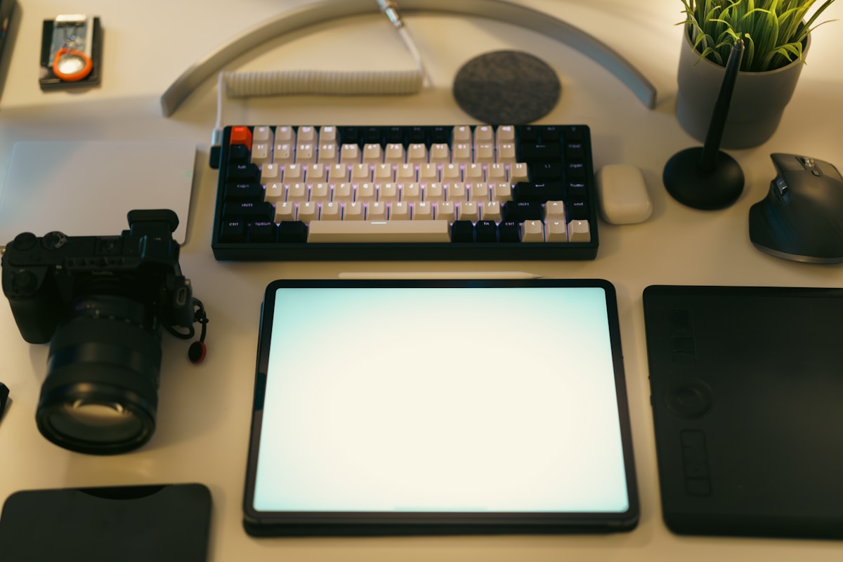 Bureau de travail avec clavier, tablette et accessoires.