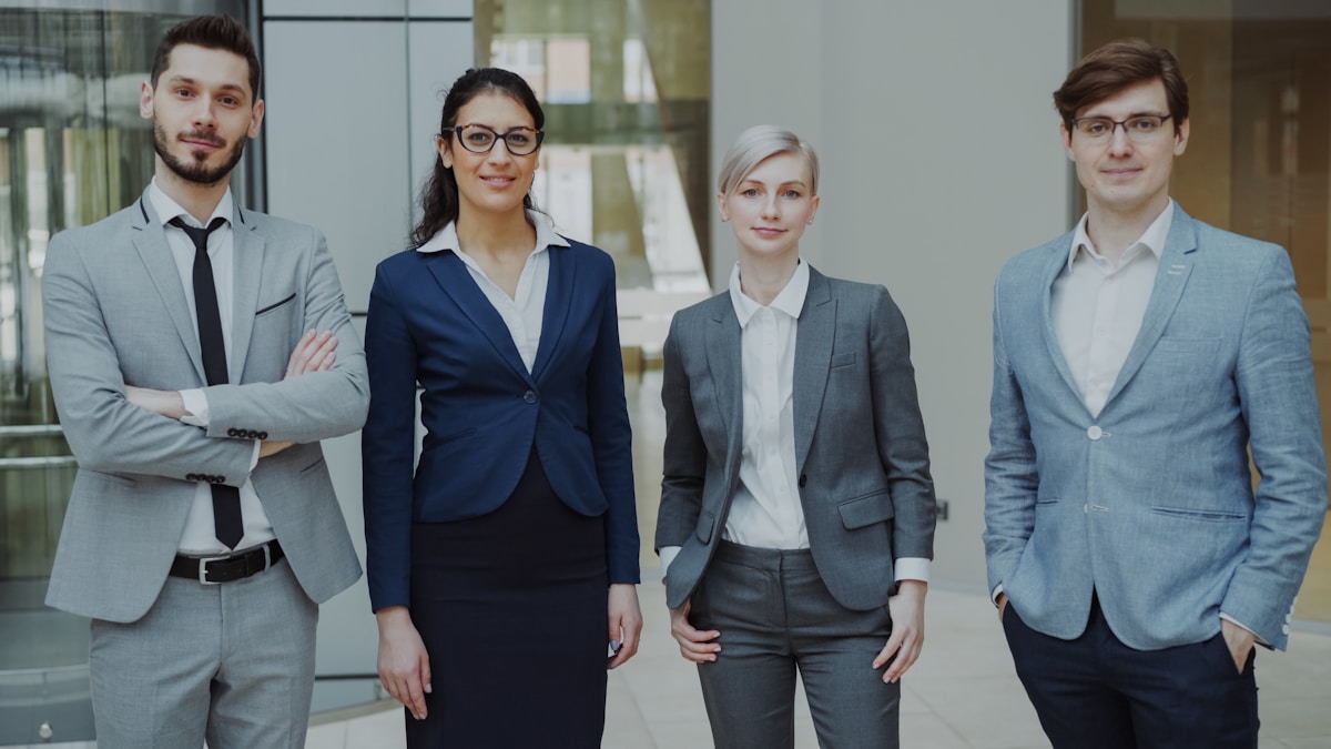 Groupe de professionnels en tenue de bureau posant ensemble.