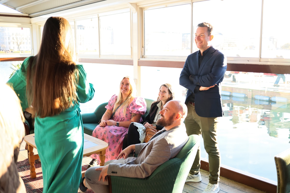 Groupe de personnes discutant dans un espace confortable et lumineux.