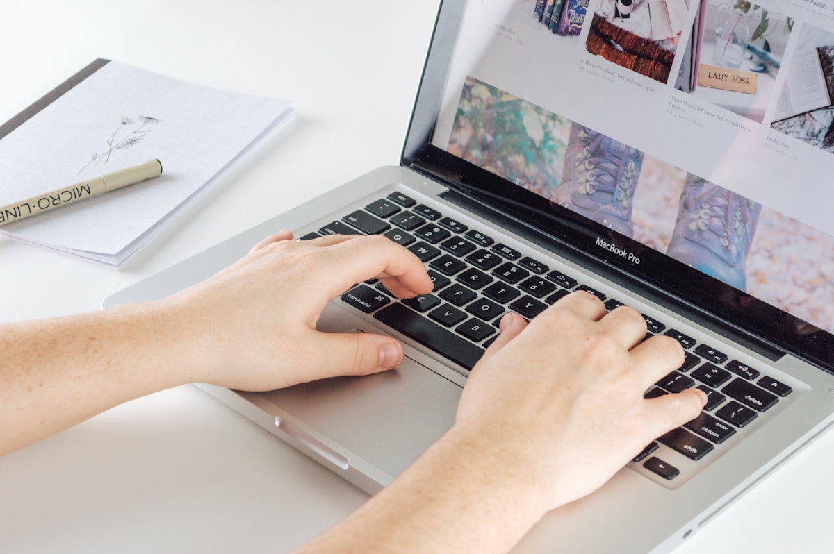 Mains tapant sur un clavier d'ordinateur portable MacBook Pro.