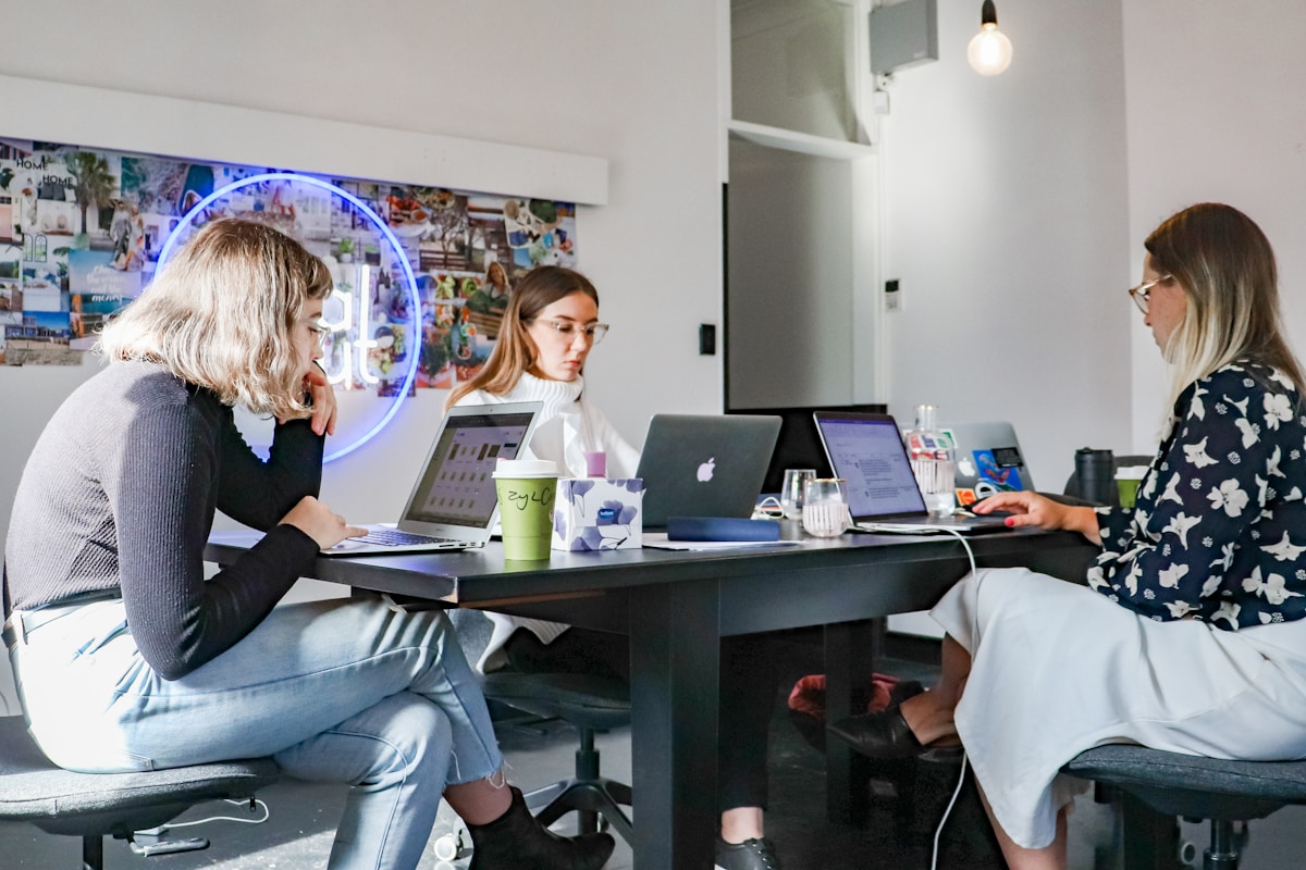 Trois femmes travaillent ensemble dans un bureau moderne.