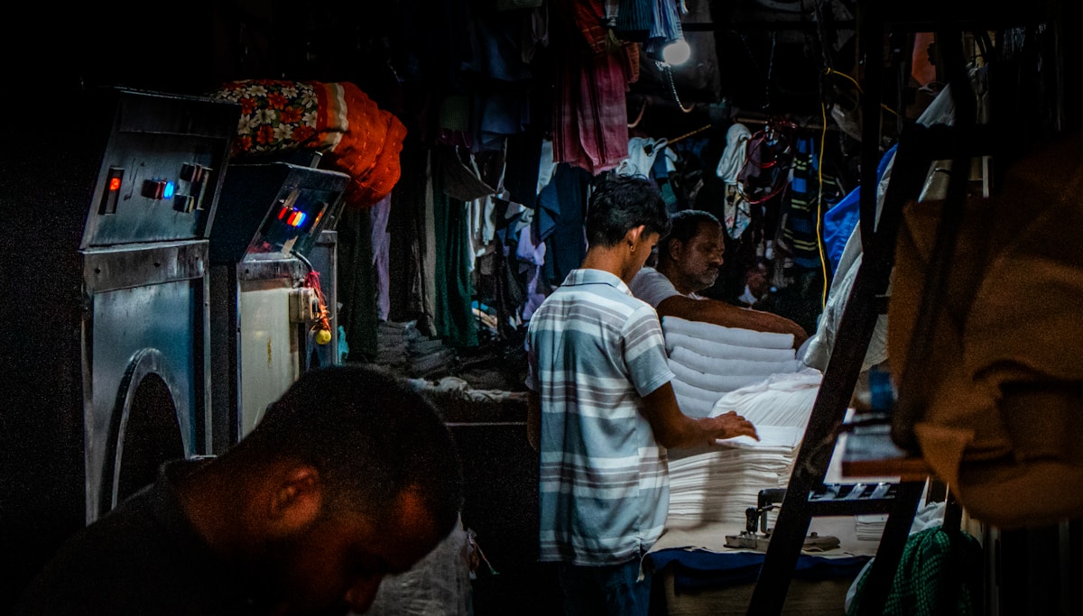 Men working in a laundry service with folded clothes.
