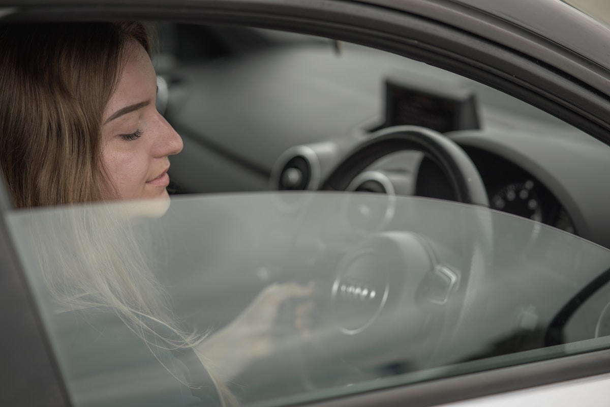a woman sitting in a car with her head out the window