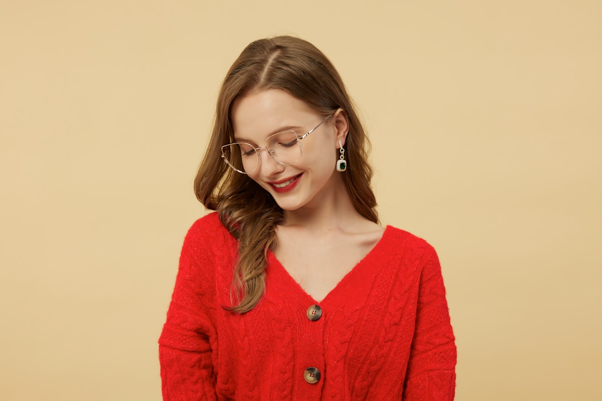 A woman in a red cardigan smiles at the camera