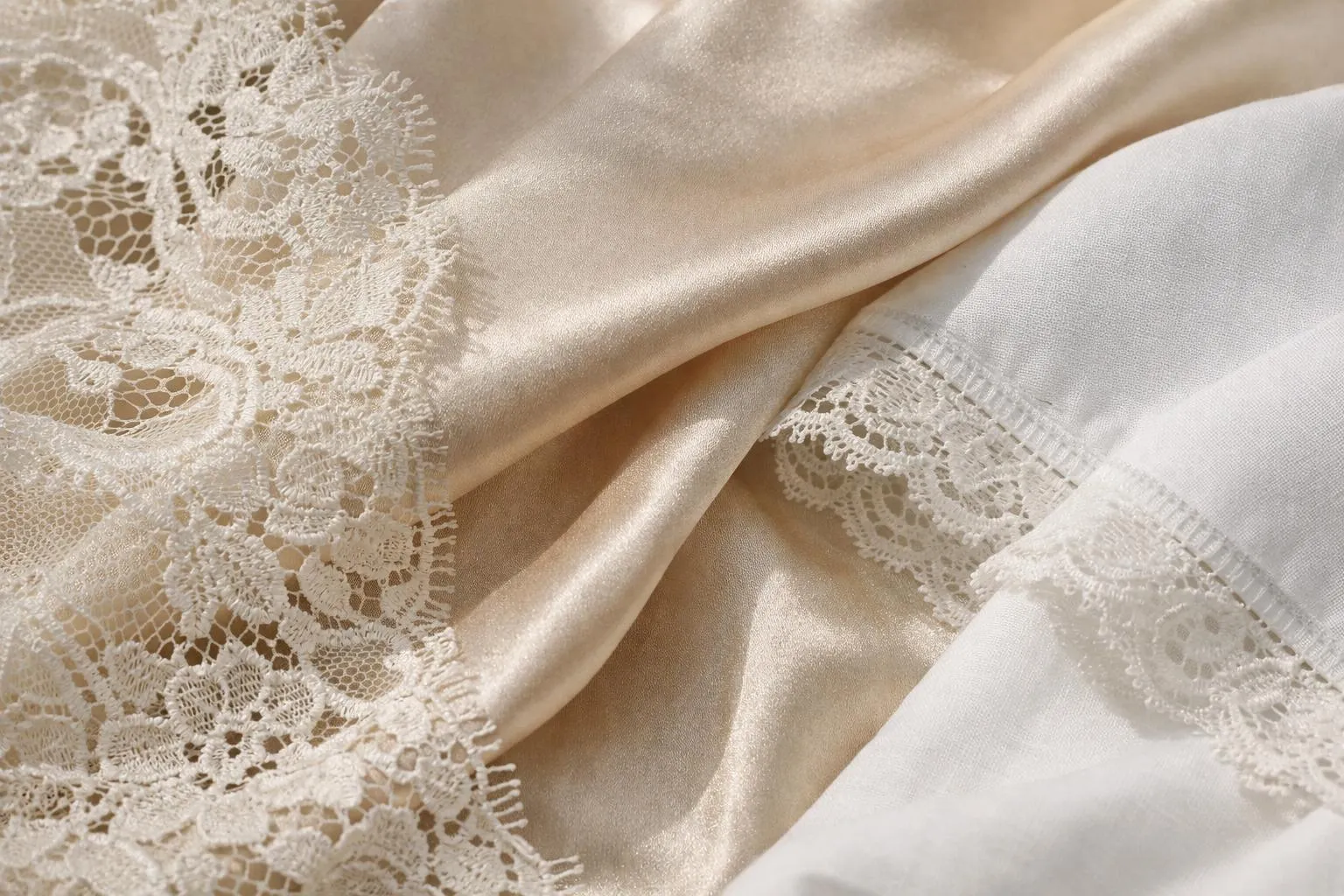 Tissu de satin et dentelle blanche, texture élégante et raffinée.