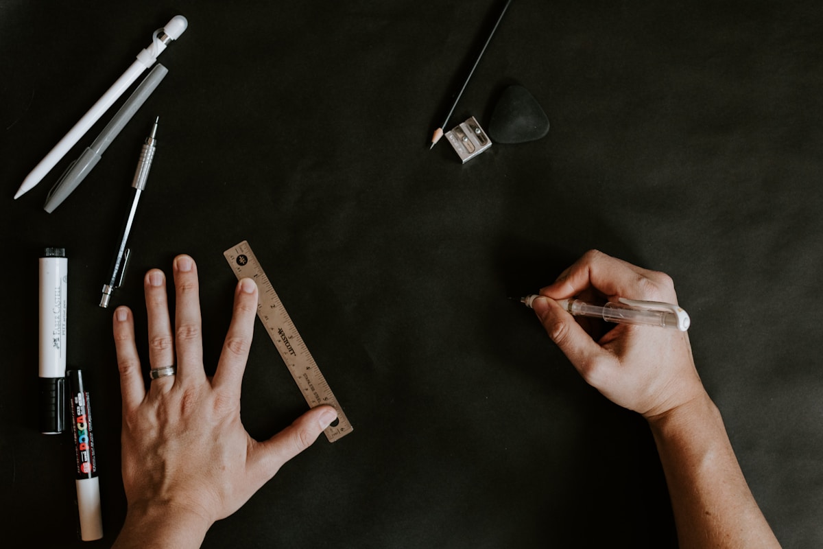 Outils de dessin et de conception sur fond noir.