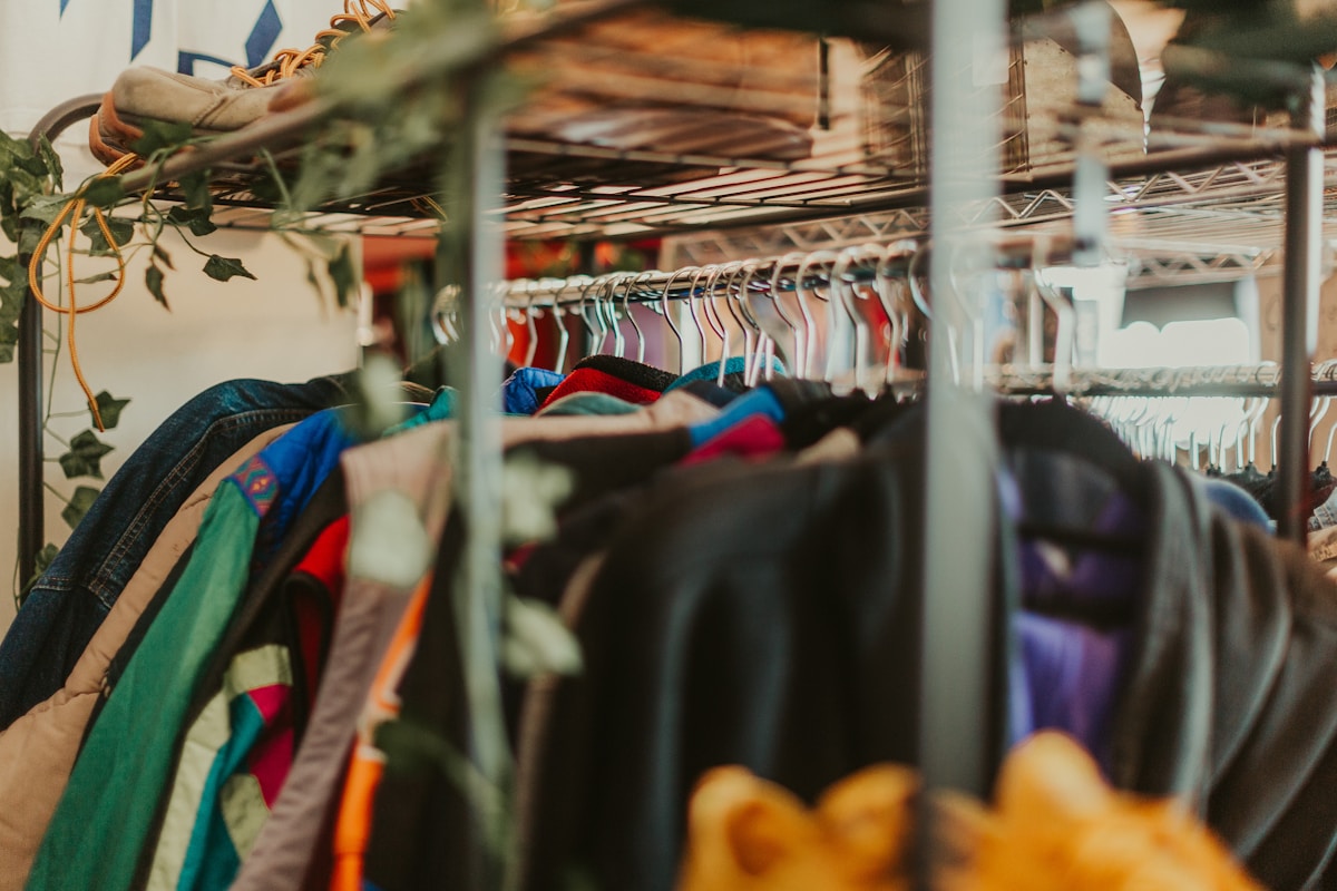 Vêtements colorés suspendus sur des cintres dans un magasin.