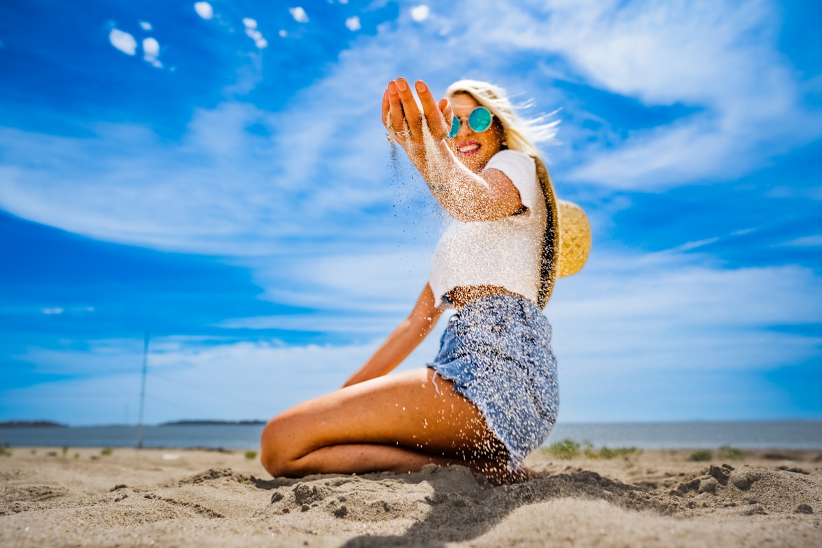 Femme blonde en maillot de bain profitant du soleil sur la plage.