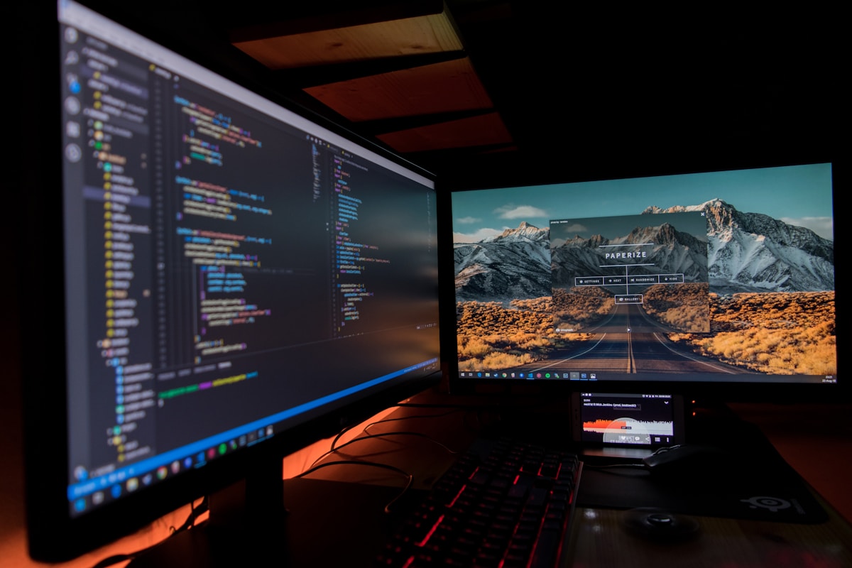 Écran d'ordinateur avec code de programmation et paysage montagneux.