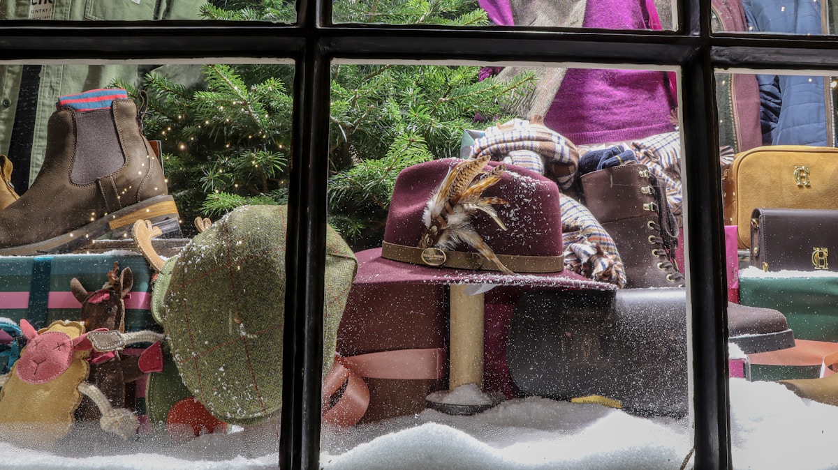 Vitrine de magasin avec bottes d'hiver, jouets et décoration de Noël.