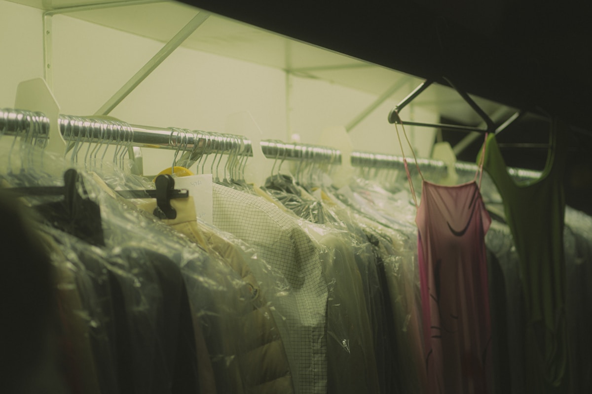 Vêtements suspendus dans un espace sombre et encombré.