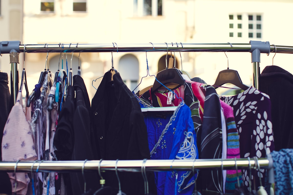 Vêtements colorés et variés suspendus sur des cintres.