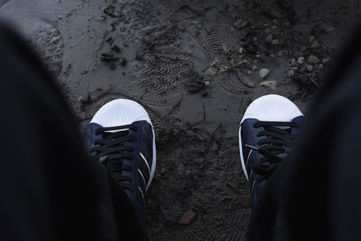 A pair of feet in black and white shoes