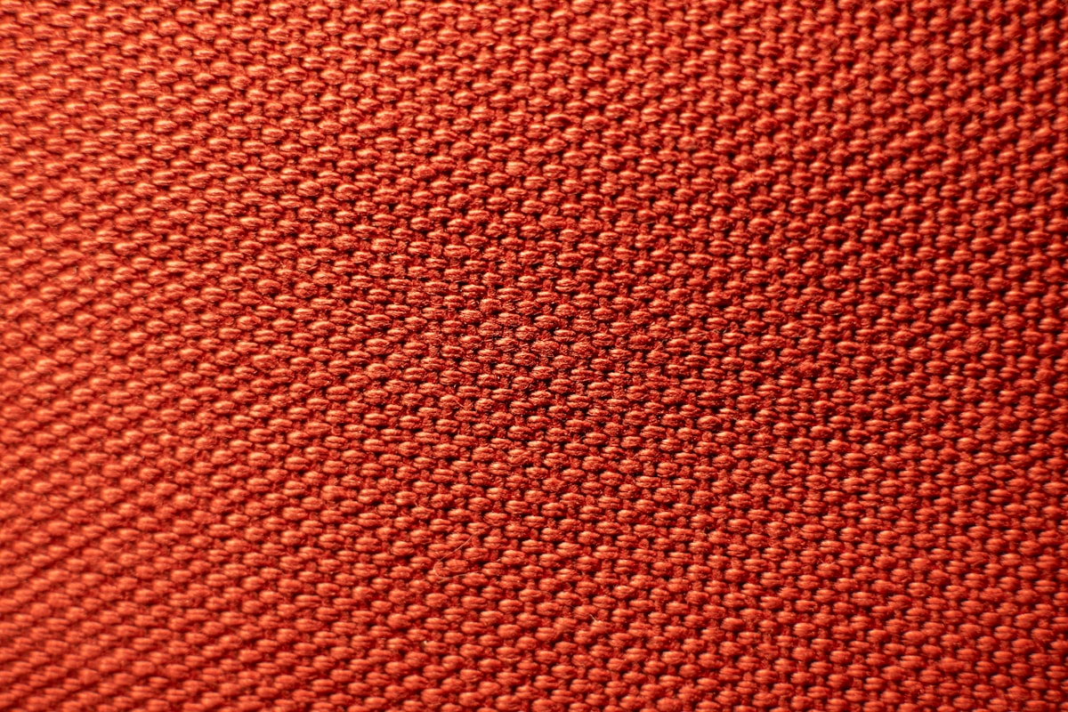 Texture de tissu tricoté rouge vif et uniforme.