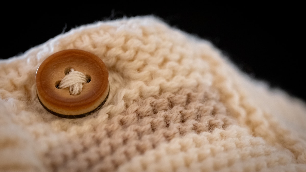 Texture de laine beige avec bouton en bois.
