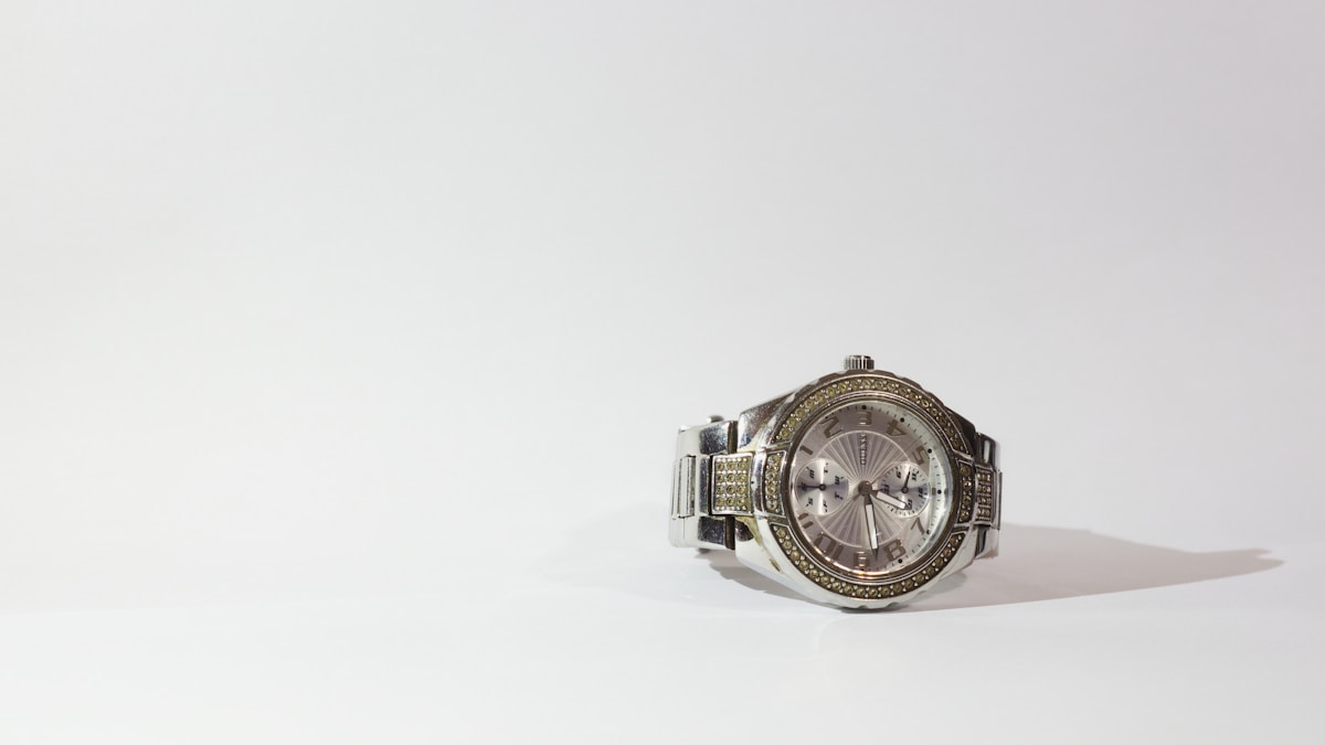 Montre de luxe en métal argenté avec des cristaux.
