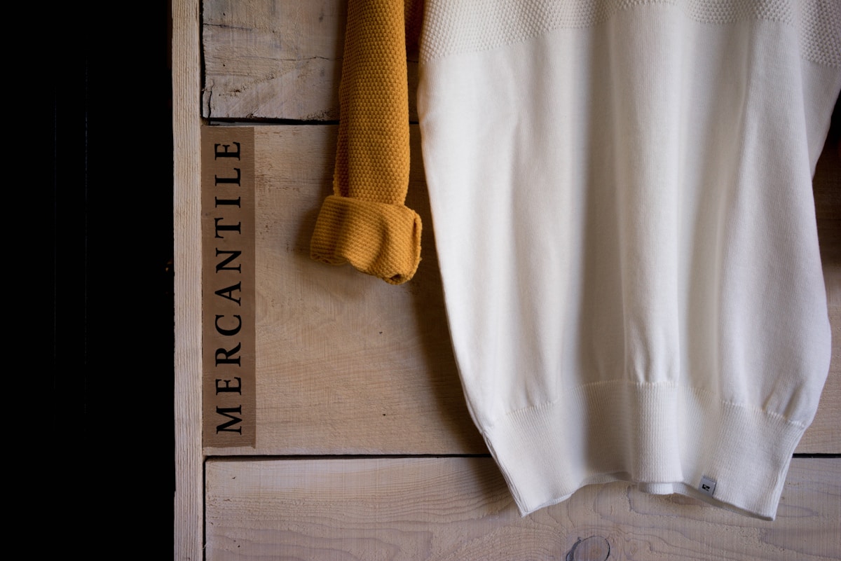 Boîte en bois, vêtement blanc et jaune, texture rustique.
