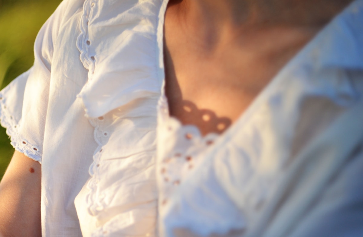 Gros plan sur une robe blanche ornée de dentelle.