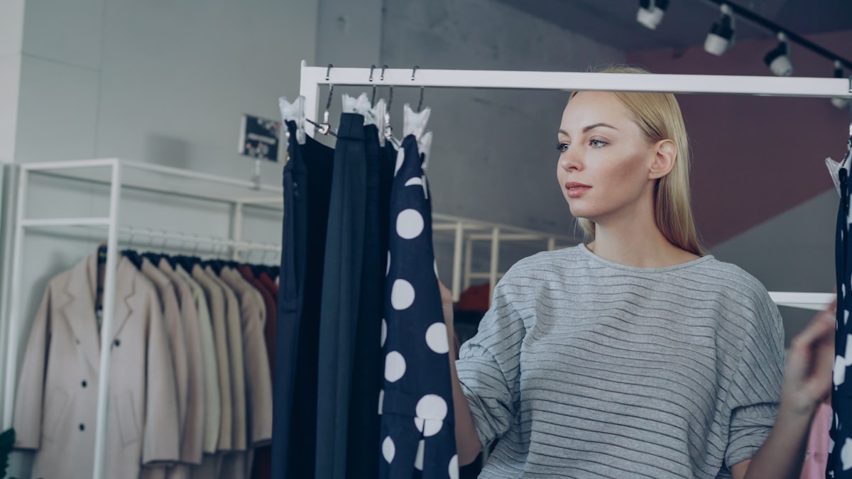 Femme blonde en tenue décontractée dans un magasin de vêtements.