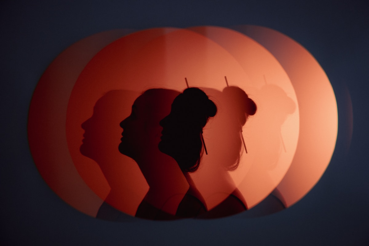 Silhouettes de personnes devant un soleil couchant orange.